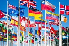 multiple country's flags waving in the sky